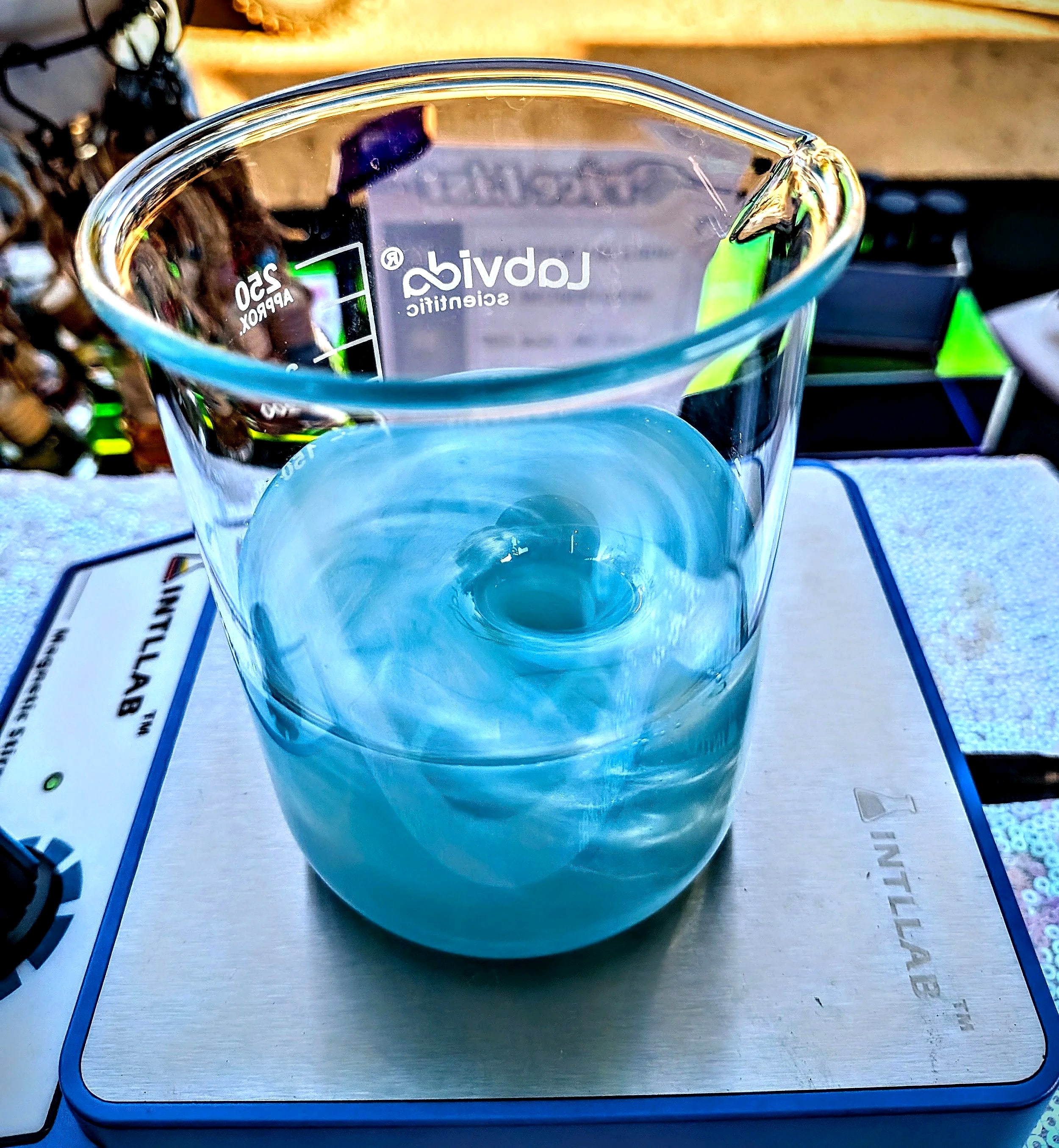 A swirling blue blend in a glass beaker on Vivian’s scale